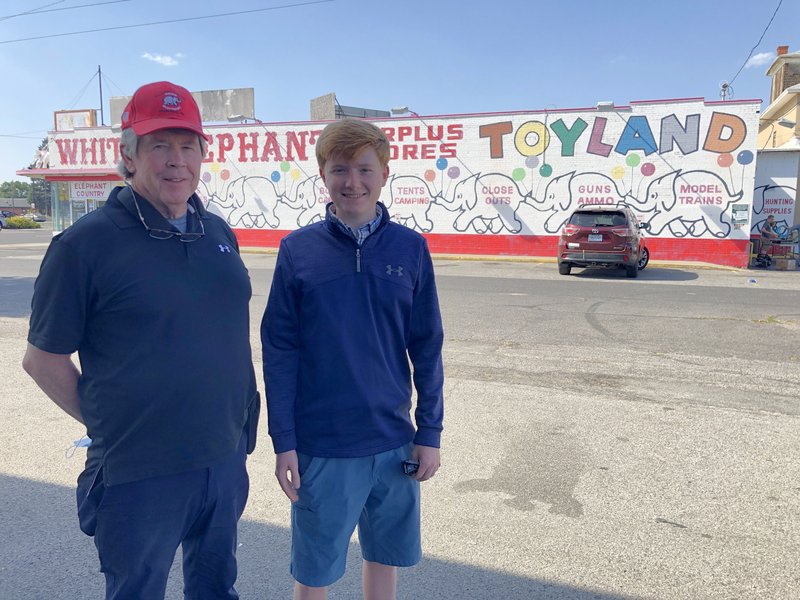Dave Knoll and grandson Alex Knoll in front of the White Elephant Surplus Stores mural.